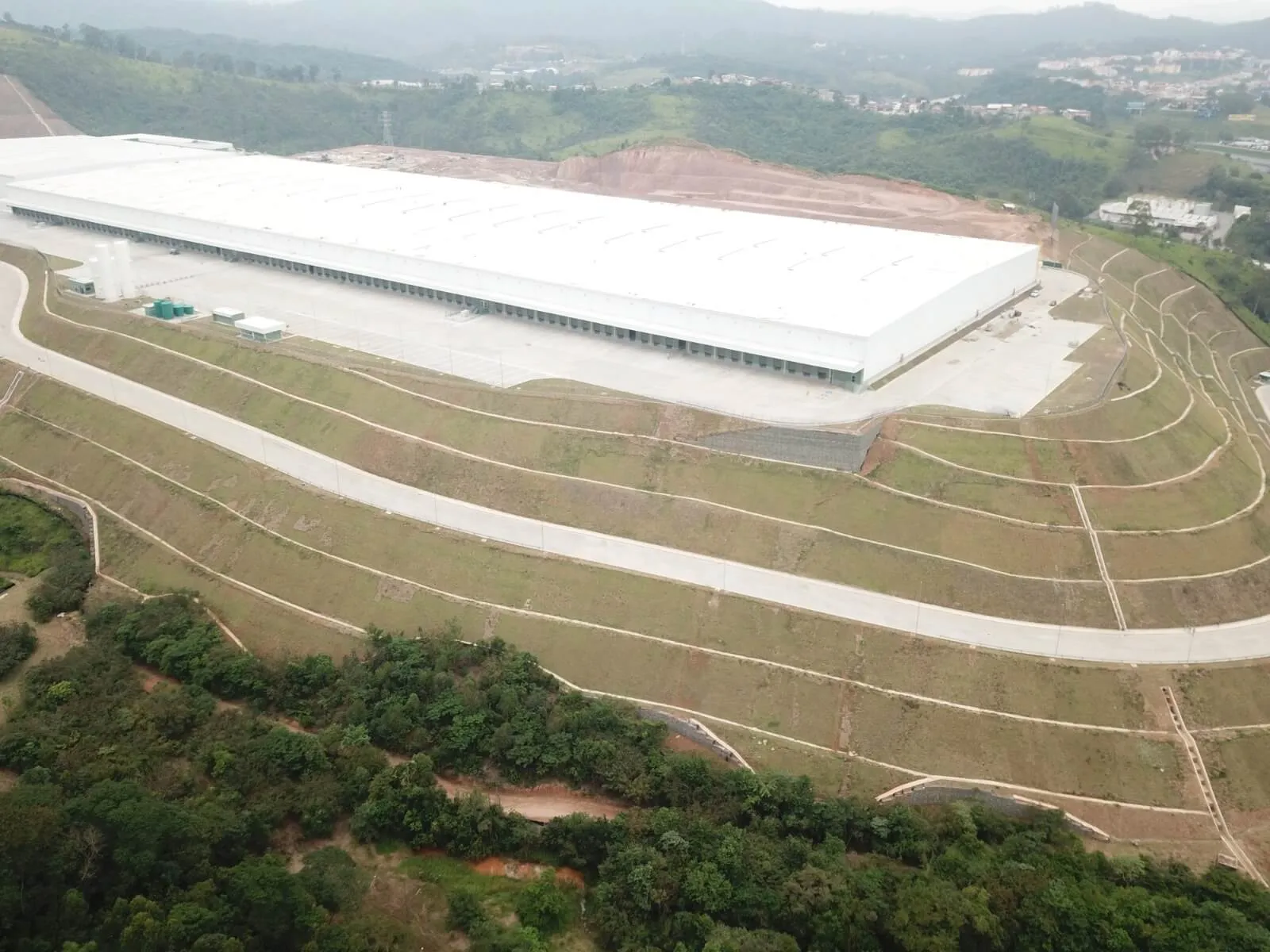 Vista aérea de galpão logístico com taludes revegetados, foto do acervo LAR