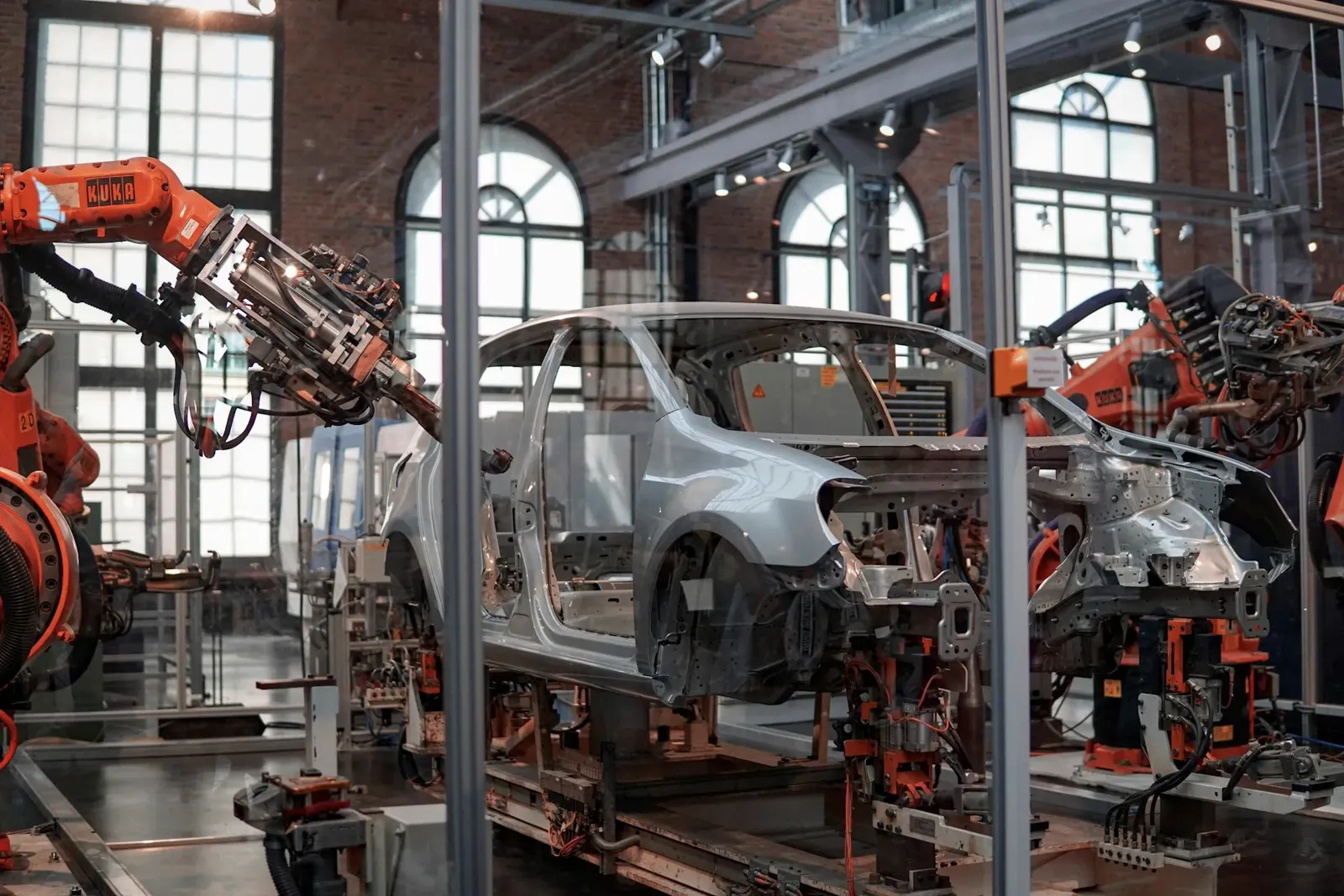 Imagem ilustrativa: linha de montagem automotiva com robôs industriais soldando carroceria